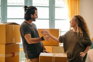 Joyful couple unpacking boxes in their new home, celebrating a fresh start.